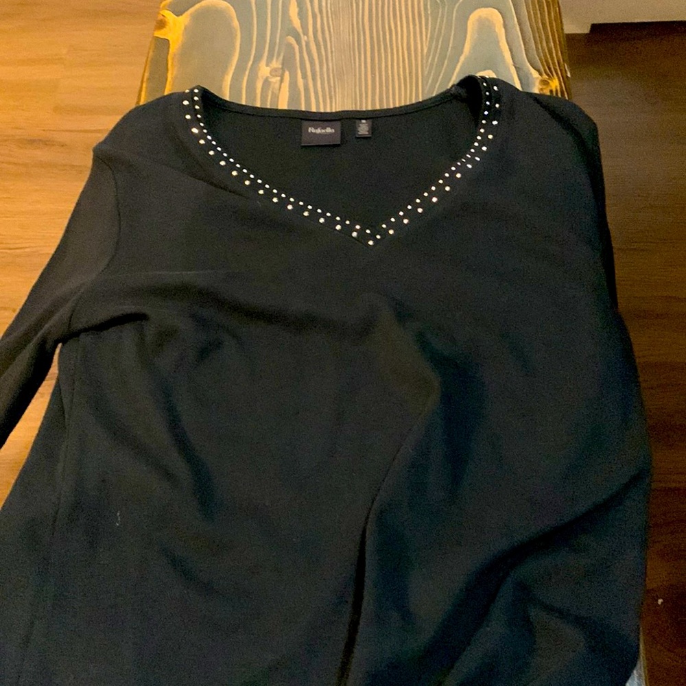 This is a black long sleeve shirt, and has diamond’s all along the neck line